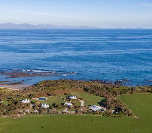 an aerial view of a golf course next to the ocean at Bear Gully Coastal Cottages in Walkerville