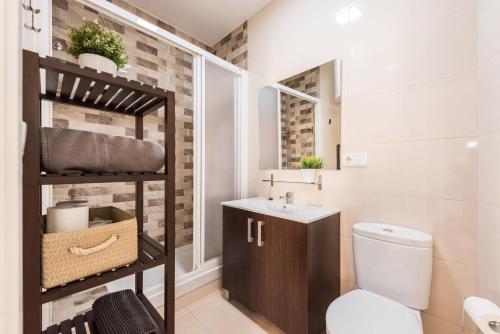 Baño pequeño con aseo y lavamanos en Living Atocha Apartments, en Madrid