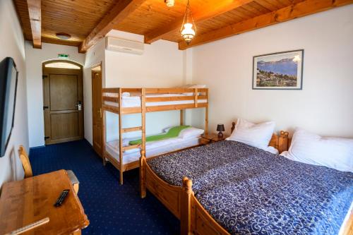 1 Schlafzimmer mit 2 Etagenbetten und einem Schreibtisch in der Unterkunft Tekergő Motel és Étterem in Velence