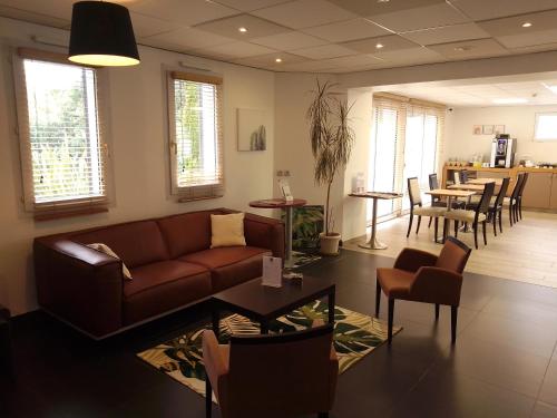 a living room with a couch and a table at Kyriad Quimper Sud in Quimper
