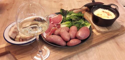 un plato de comida y una copa de vino en una mesa en PAUSE ROMANTIQUE EN PAYS BRAYAUD en Châtel-Guyon