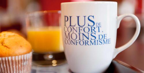 une tasse de café et un verre de jus d'orange dans l'établissement Kyriad Quimper Sud, à Quimper