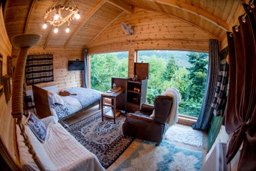 a living room with a large window in a log cabin at Kedra Village in Kédra