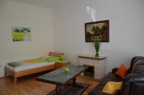 ein Wohnzimmer mit einem Sofa und einem Tisch in der Unterkunft Ferienwohnung Birgit in Eisenstadt