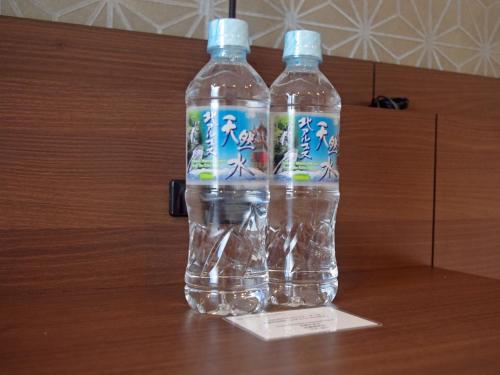 due bottiglie d'acqua sedute sopra un tavolo di Tosei Hotel Cocone Kanda a Tokyo