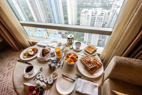 a table with breakfast food on it in front of a window at Shangri-La Residences The Fort, Manila in Manila
