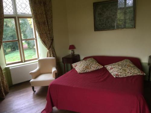 a bedroom with a red bed and a chair and window at Château de Villers-Châtel in Villers-Châtel