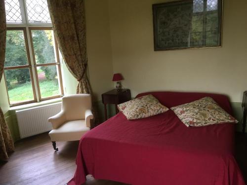 - une chambre avec un lit rouge, une chaise et une fenêtre dans l'établissement Château de Villers-Châtel, à Villers-Châtel