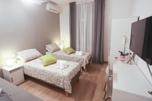 een woonkamer met 2 bedden en een flatscreen-tv bij Residenza Leone in Florence