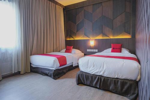 En eller flere senge i et værelse på RedDoorz Plus near Pantai Coastarina 2