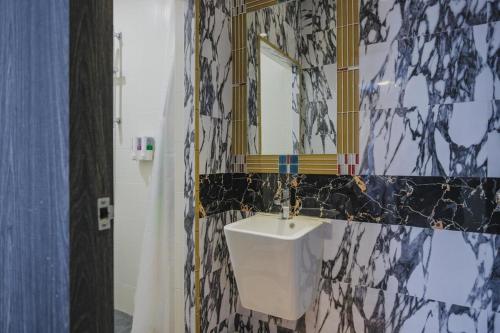 a bathroom with a sink and a mirror at RedDoorz Plus near Pantai Coastarina 2 Batam in Batam Center
