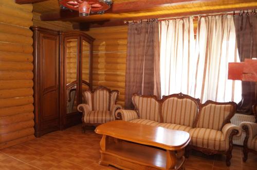 a living room with two chairs and a table at Норіс in Migovo
