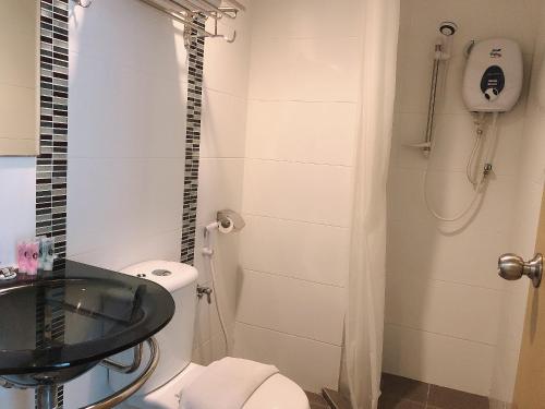 a bathroom with a toilet and a sink and a shower at Tras Mutiara Hotel Bentong in Bentong