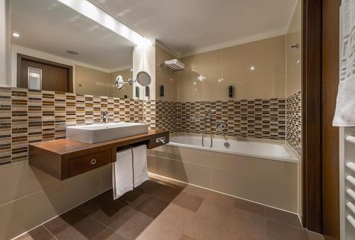 a bathroom with a sink and a bath tub and a tubermott at Aparthotel Treudelberg in Hamburg