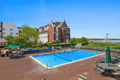 uma piscina com mesas e cadeiras e um edifício em Montauk Manor em Montauk