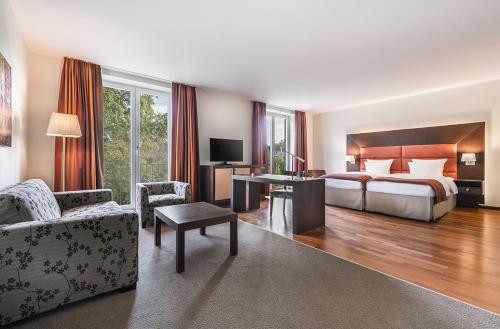 een hotelkamer met een slaapkamer met 2 bedden en een bureau bij Aparthotel Treudelberg in Hamburg