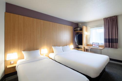 um quarto de hotel com duas camas e uma janela em B&B HOTEL Aubagne Gémenos em Gémenos