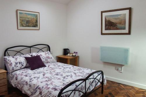 a bedroom with a bed with a purple comforter at The Piggery at Moorfield Barns in Praze an Beeble