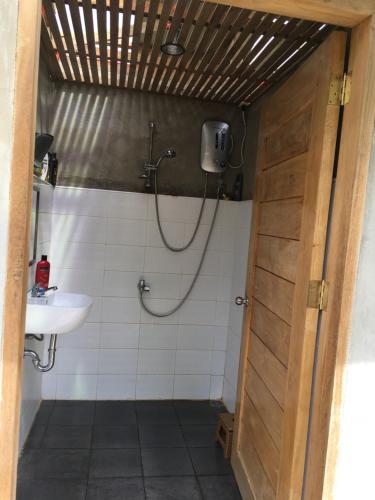 a bathroom with a shower and a sink at B&R Hostel Nagtabon in Bacungan