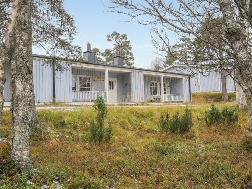 ein weißes Haus mit Bäumen im Vordergrund in der Unterkunft Holiday Home Saariselän väärtin kammi 1 by Interhome in Saariselkä