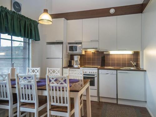 塔庫沃里的住宿－Holiday Home Levähdys by Interhome，厨房配有白色橱柜和桌椅