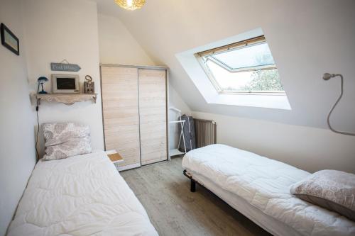 een slaapkamer met 2 bedden en een raam bij La Maison Bleue in Baden