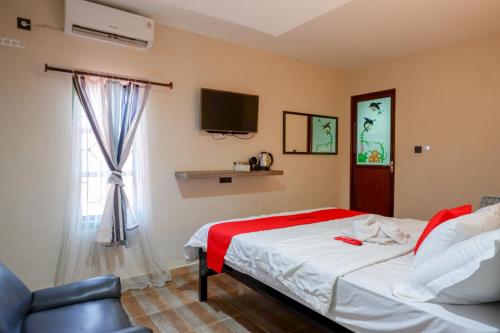 una camera con letto, TV e finestra di RedDoorz Syariah At Jalan Jenderal Sudirman Palopo a Palopo