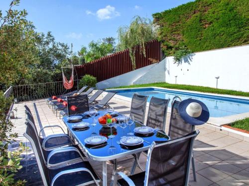 a table with a blue table cloth next to a pool at Holiday Home Paris by Interhome in Calonge