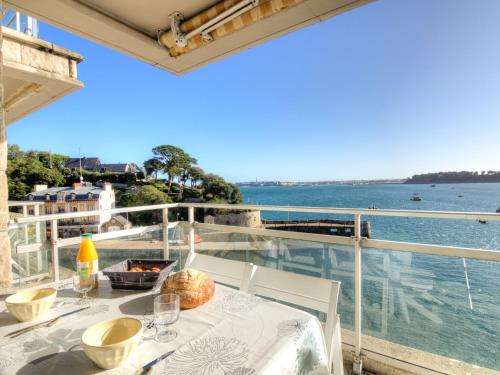 a table on a balcony with a view of the water at Apartment Le Bellevue-1 by Interhome in Dinard