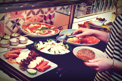 a person holding a spoon over a table of food at Melbo's Home in Lindau