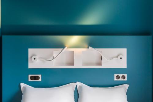 a room with a bed with a light above it at Ibis Budget Perigueux Boulazac in Boulazac