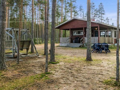 een klein huis in het bos met een schommel bij Holiday Home Mäntyniemi by Interhome in Luhtanen