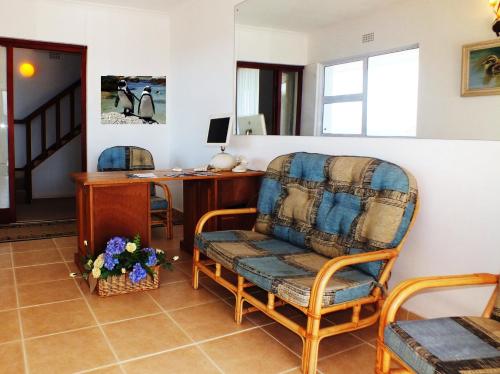 a living room with a chair and a desk at Penguinden - load-shedding free in Simonʼs Town