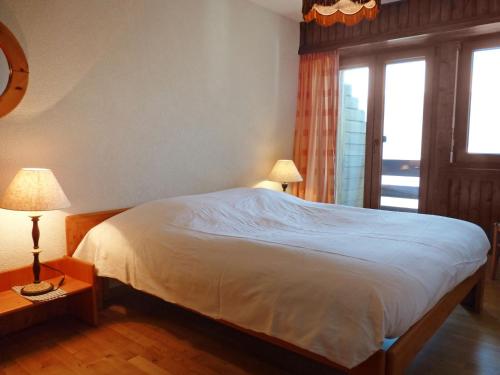 オヴロナにあるApartment Comère by Interhomeのベッドルーム1室(ベッド1台、ランプ2つ、窓付)