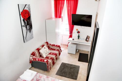 uma sala de estar com um sofá vermelho e uma secretária em Gateway Residence em Roma