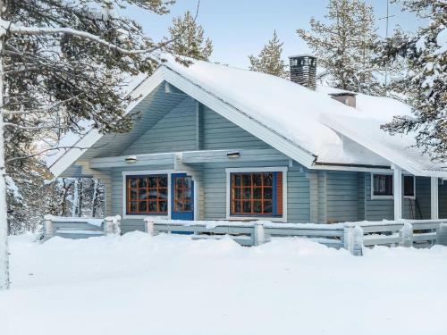 a blue house with snow on the roof at Holiday Home Keromaja by Interhome in Kakslauttanen