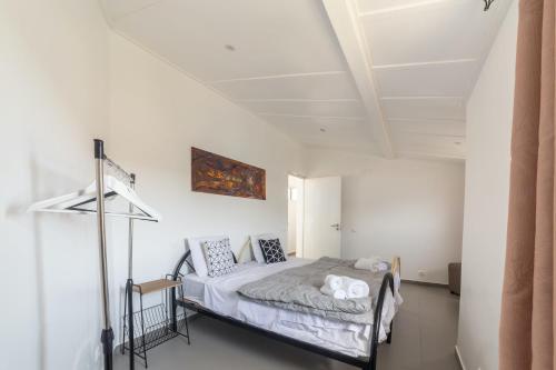a bedroom with a bed in a white room at A Casa da Mizi in Praia