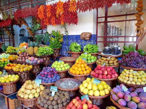 a display of fruits and vegetables in baskets in a market at Agnelo Comfort - Accommodation H V in Funchal