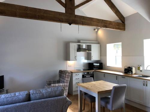 a kitchen with a couch and a table in a room at The Dairy, Wolds Way Holiday Cottages, 1 bed studio in Cottingham