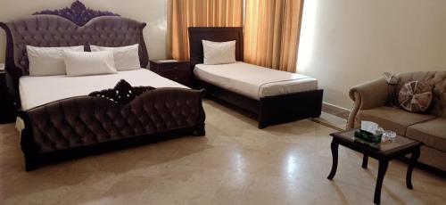 a hotel room with a bed and a couch at Executive Galaxy Guest House in Islamabad