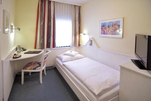 a hotel room with a bed and a desk at Hotel - Restaurant Hirsch in Heimsheim