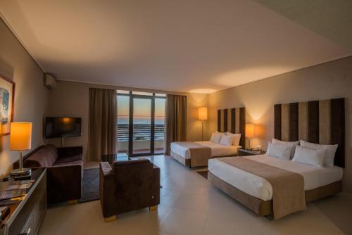 a hotel room with two beds and a television at Vila Gale Ampalius in Vilamoura