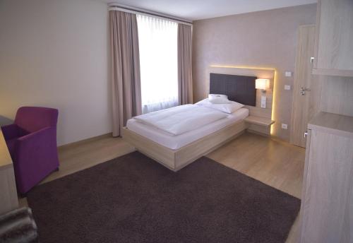 a bedroom with a white bed and a large window at Hotel - Restaurant Hirsch in Heimsheim