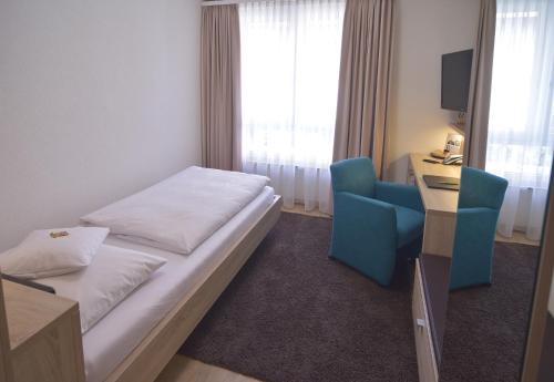 a bedroom with a bed and a desk and a chair at Hotel - Restaurant Hirsch in Heimsheim