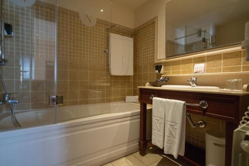 a bathroom with a tub and a sink at Laguna Nivaria Hotel & Spa in La Laguna