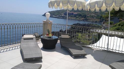 a balcony with chairs and a view of the water at B&B Acireale - Il Cavalluccio Marino Fronte Mare in Acireale