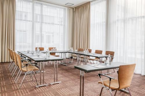 a conference room with tables and chairs and windows at IntercityHotel Dresden in Dresden