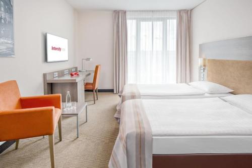 a hotel room with a bed and a desk at IntercityHotel Dresden in Dresden