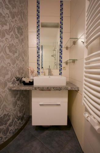 a bathroom with a sink and a mirror at Faupel Ferienwohnung in Mülverstedt