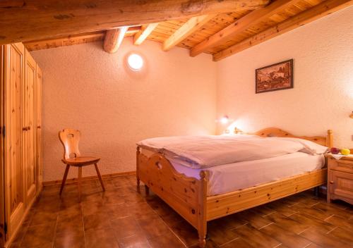 um quarto com uma cama de madeira e uma cadeira em Apartment Paradise em Livigno